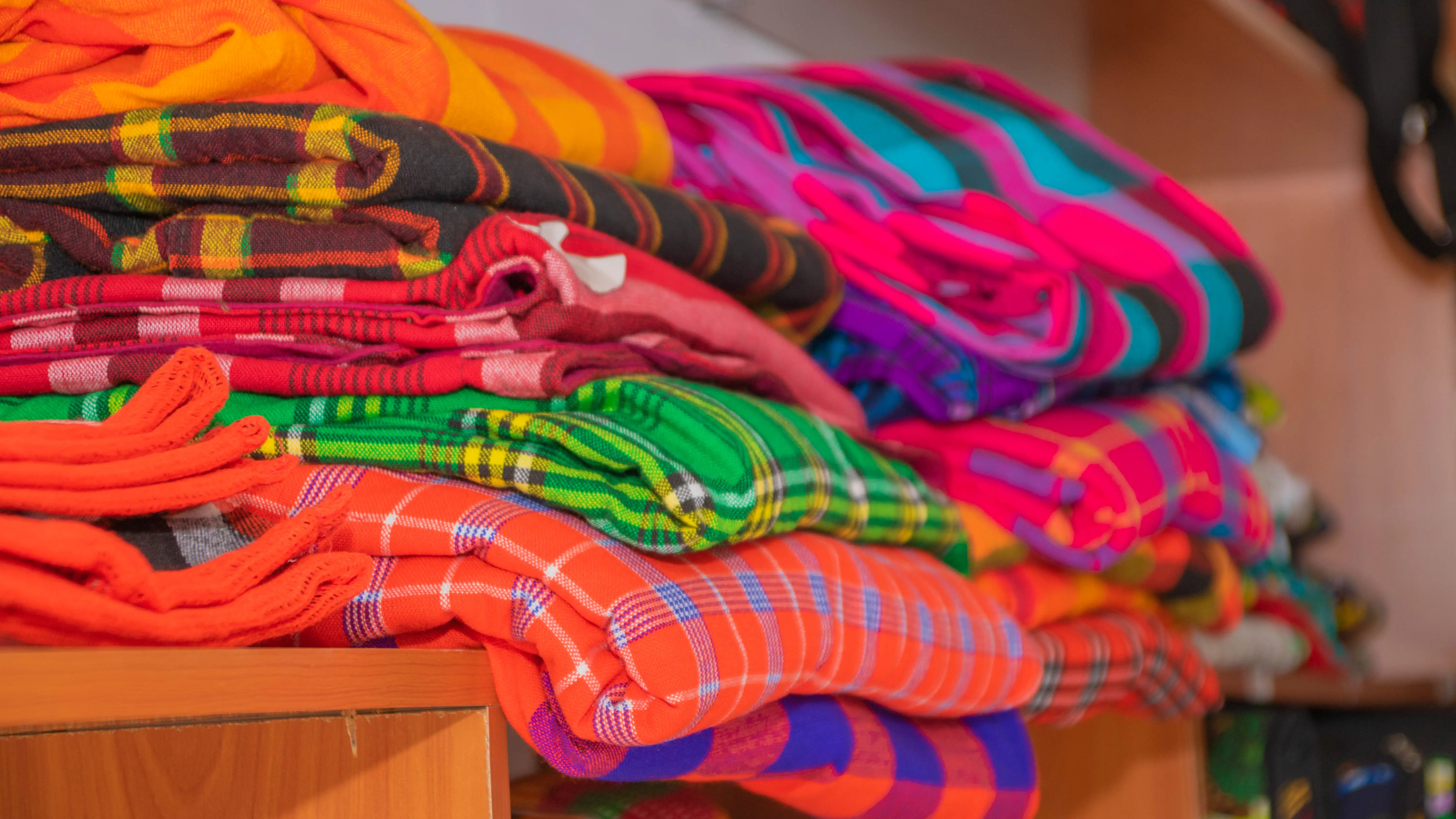 Close-up of stacked, vibrant plaid Maasai shuka blankets